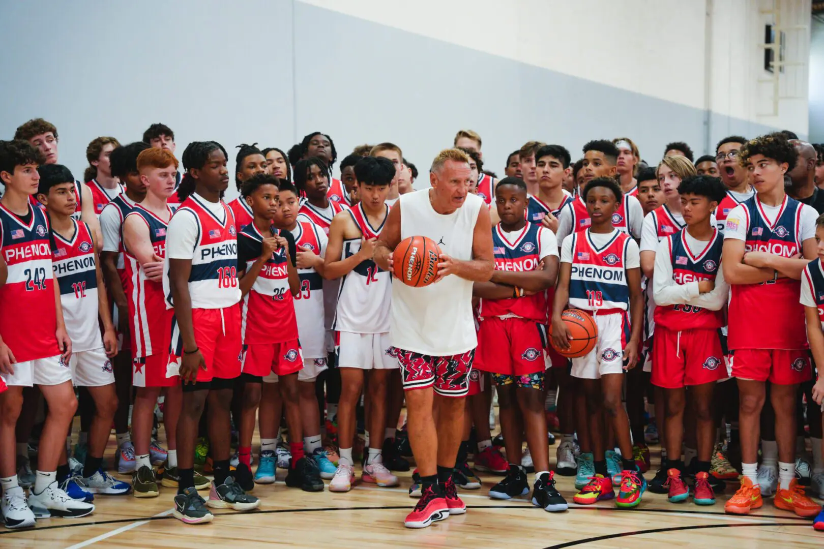Coach teaching basket ball to some players