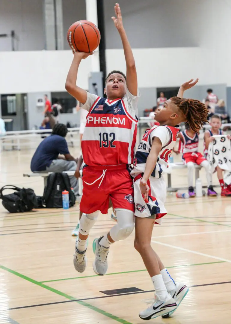Small boy along with a girl playing basket ball