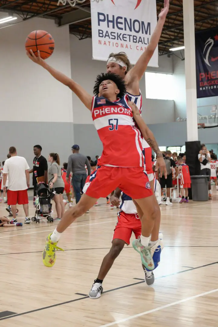 Two players playing basket ball in a court